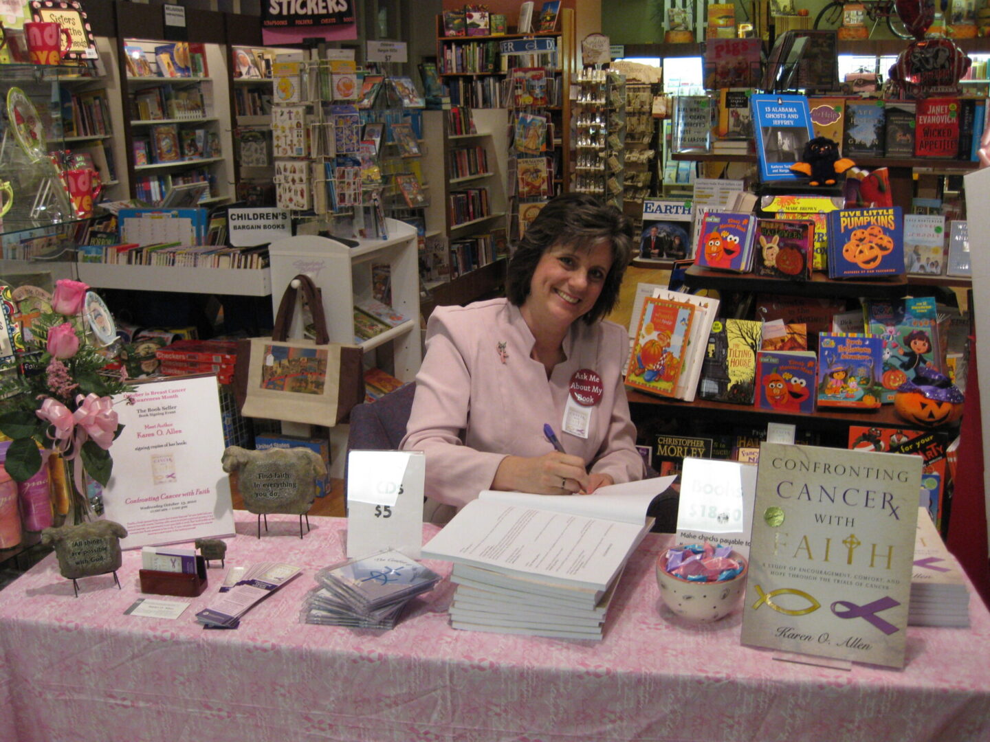 A woman sitting at a table with books on it.