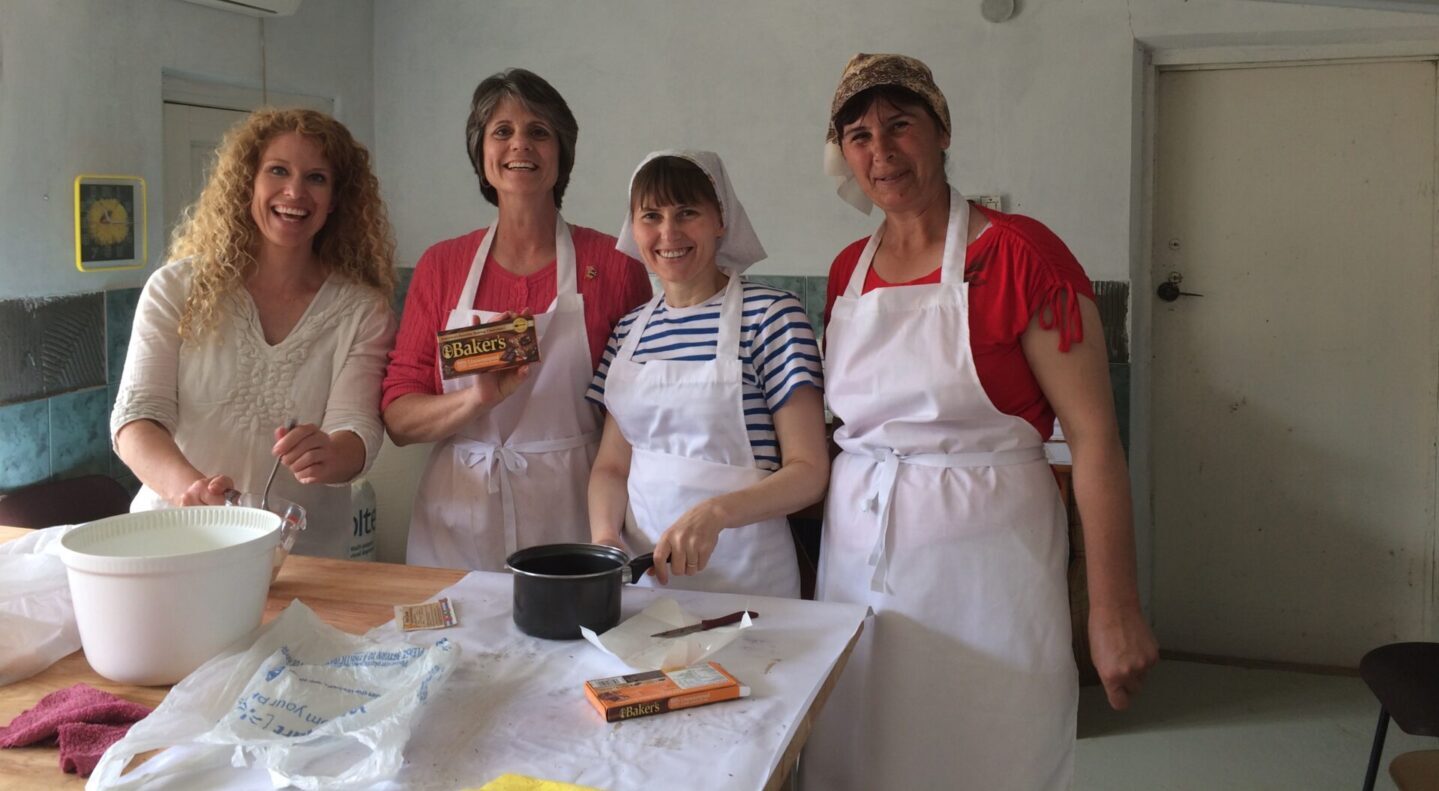 A group of women standing in front of a table.