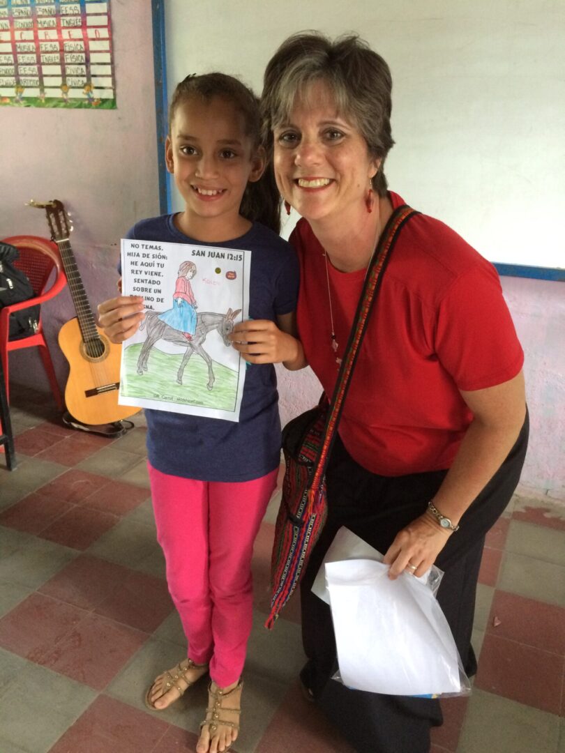 A woman and girl holding up a book.