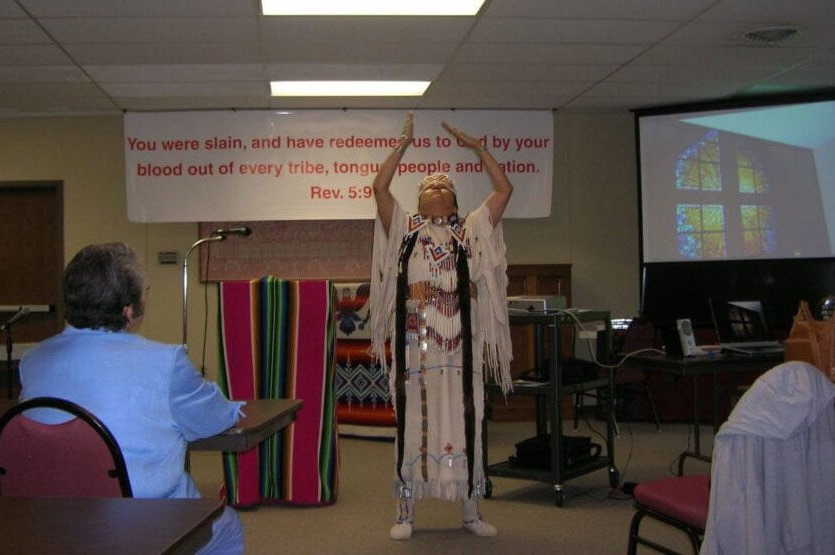 A woman in native american clothing standing up.