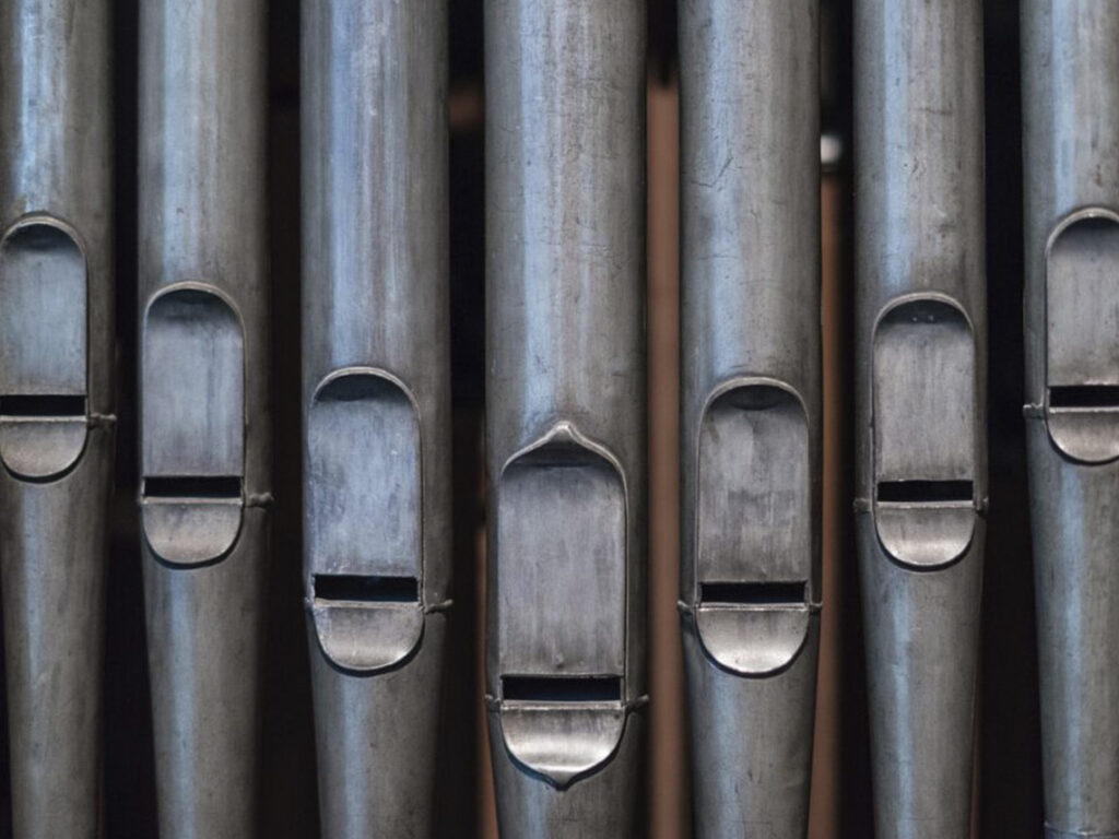 A close up of the metal bars on an organ.