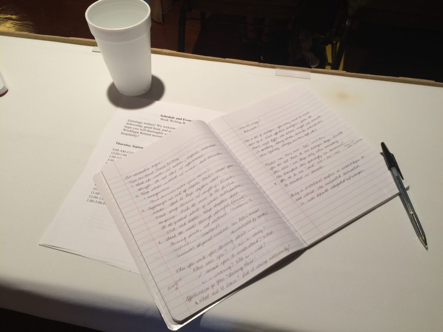 A white table with some papers and a cup