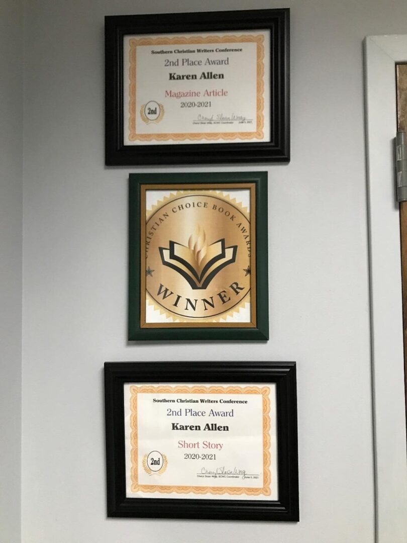 Three framed awards hanging on a wall.