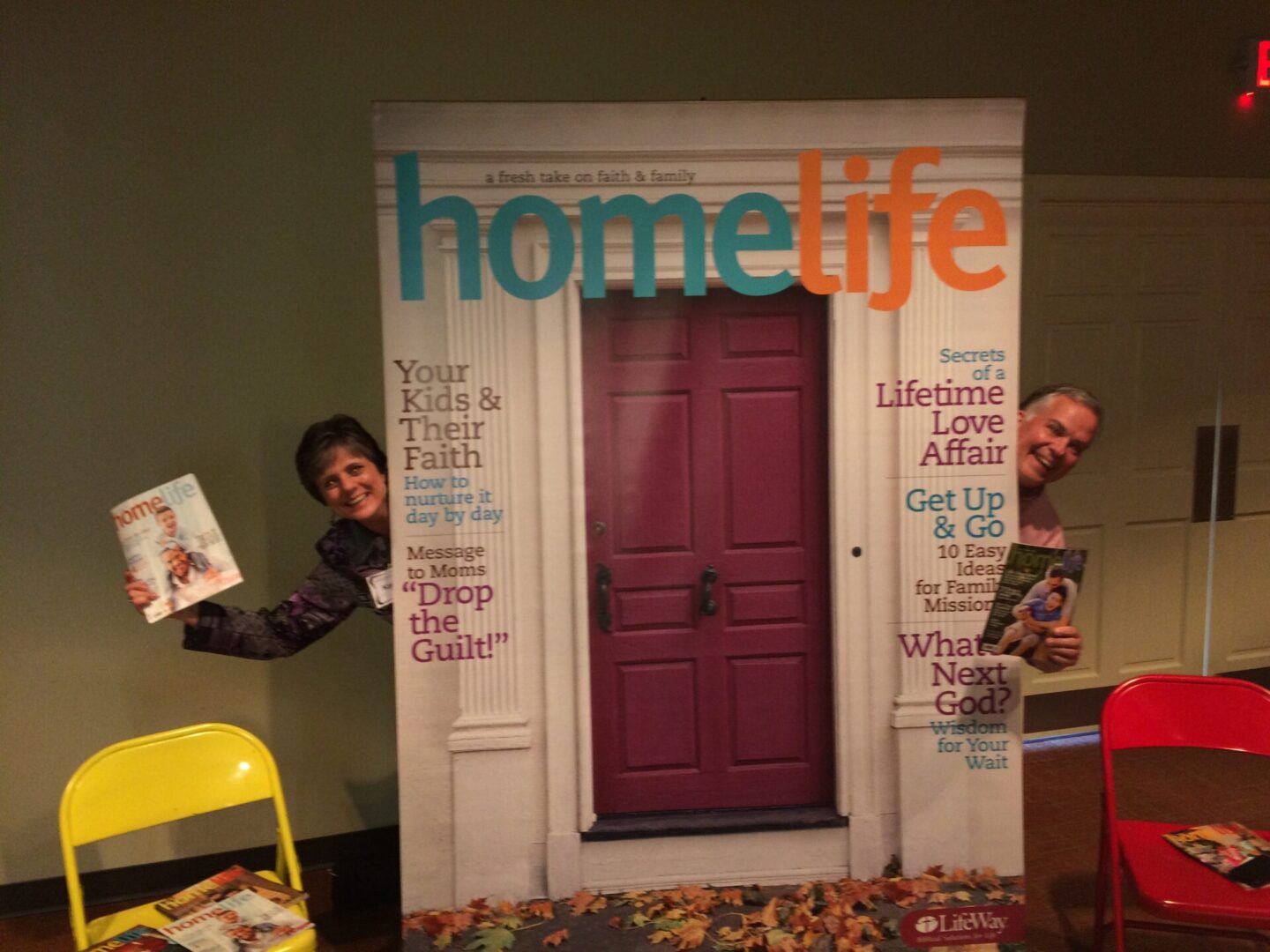 Two people standing in front of a door with the words " home life ".