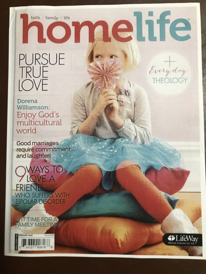 A magazine cover with a girl holding a flower.