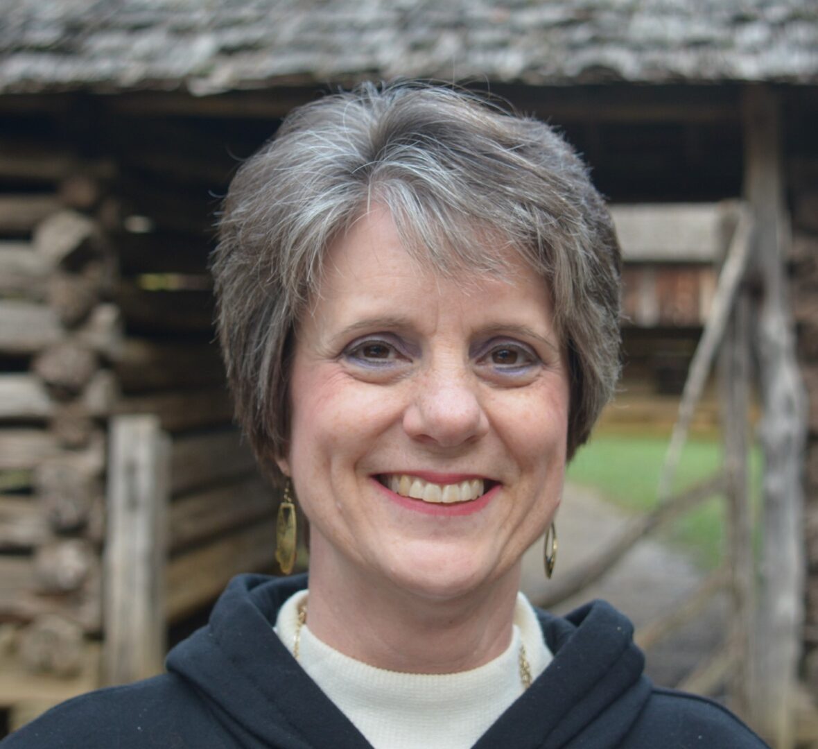 A woman with short hair is smiling for the camera.