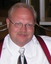 A man with glasses and a tie