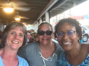 Three women smiling for a picture together.