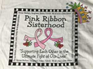 A pillow with the words pink ribbon sisterhood on it.