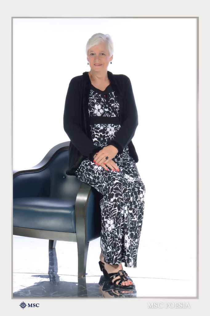 A woman sitting on top of a chair in front of a wall.