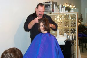 A man is cutting the hair of a woman.