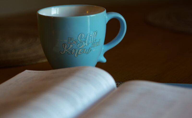A blue coffee cup sitting on top of a table.