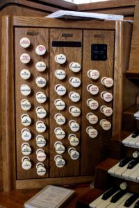 A wooden organ with many buttons on it.