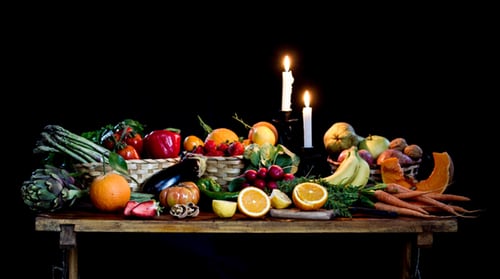A table with fruits and candles on it