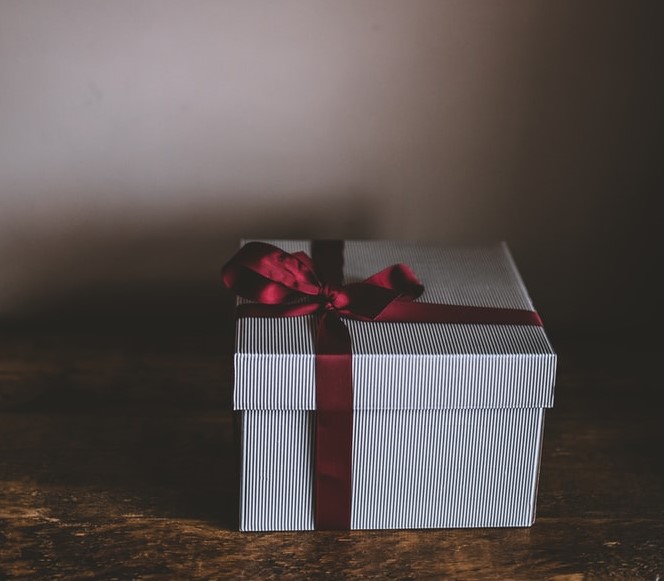 A white box with red ribbon on top of it.