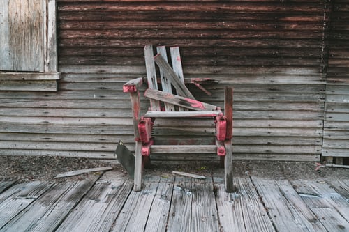 A wooden chair sitting on top of a porch.