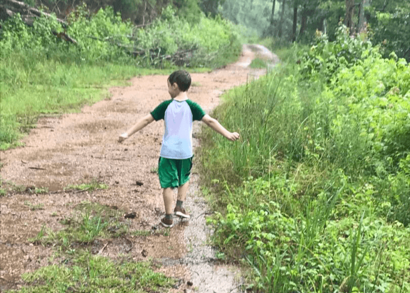 A young boy is walking down the road