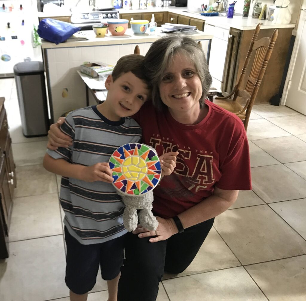 A woman and boy holding up a paper plate.
