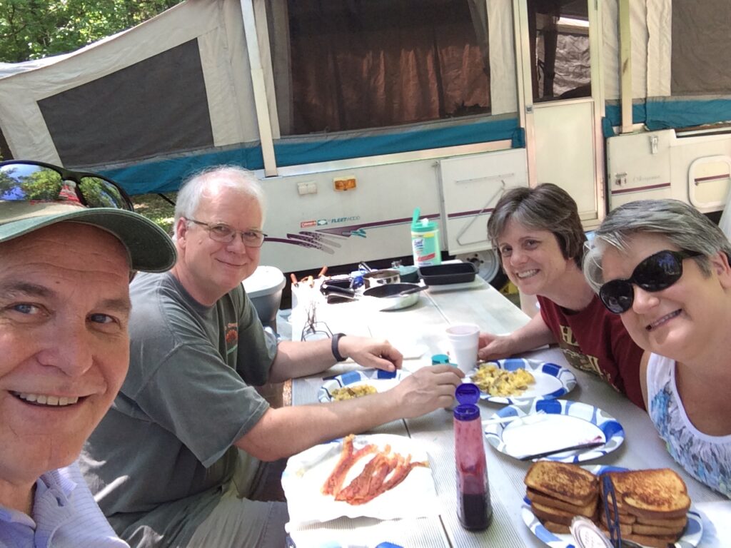 A group of people sitting at a table eating food.