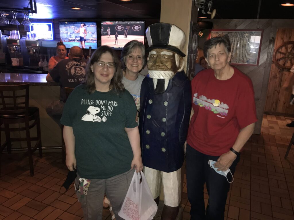 A group of people posing with a statue.