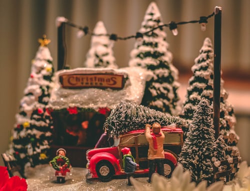 A christmas scene with trees and a truck.