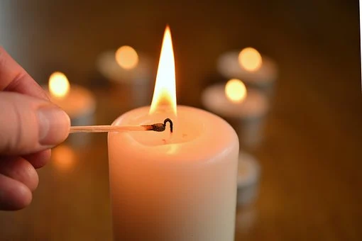 A candle is lit with one match in it.