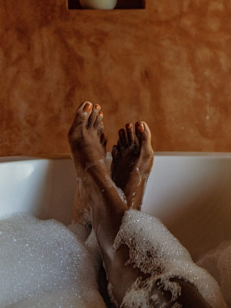 A person 's feet in the tub with foam.
