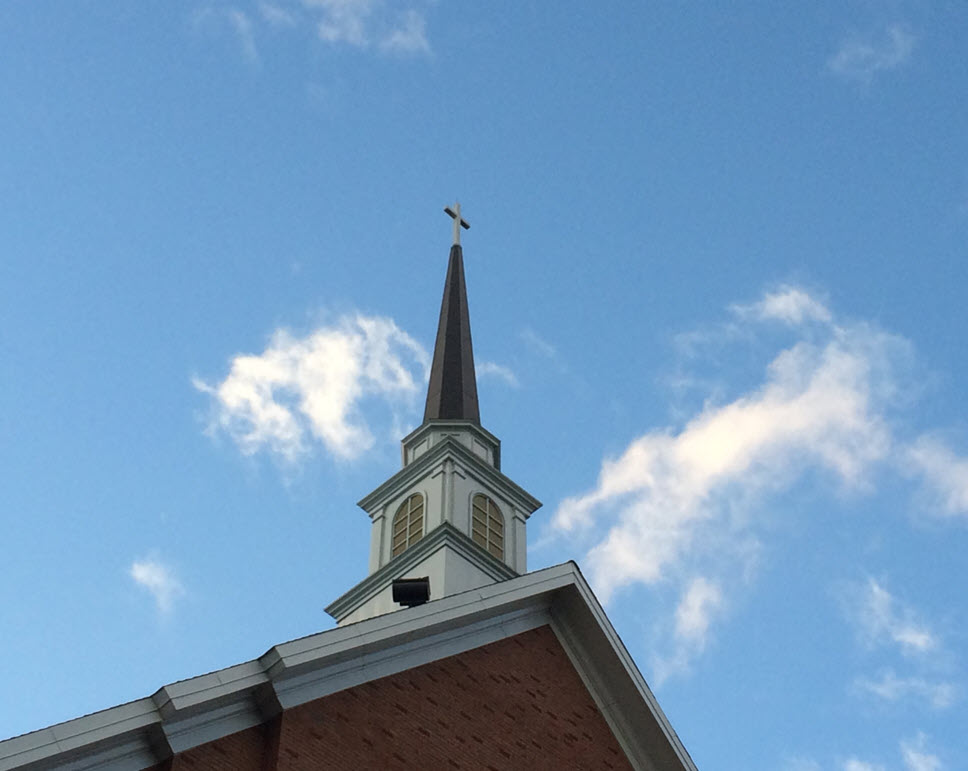 A church steeple with a cross on top of it.