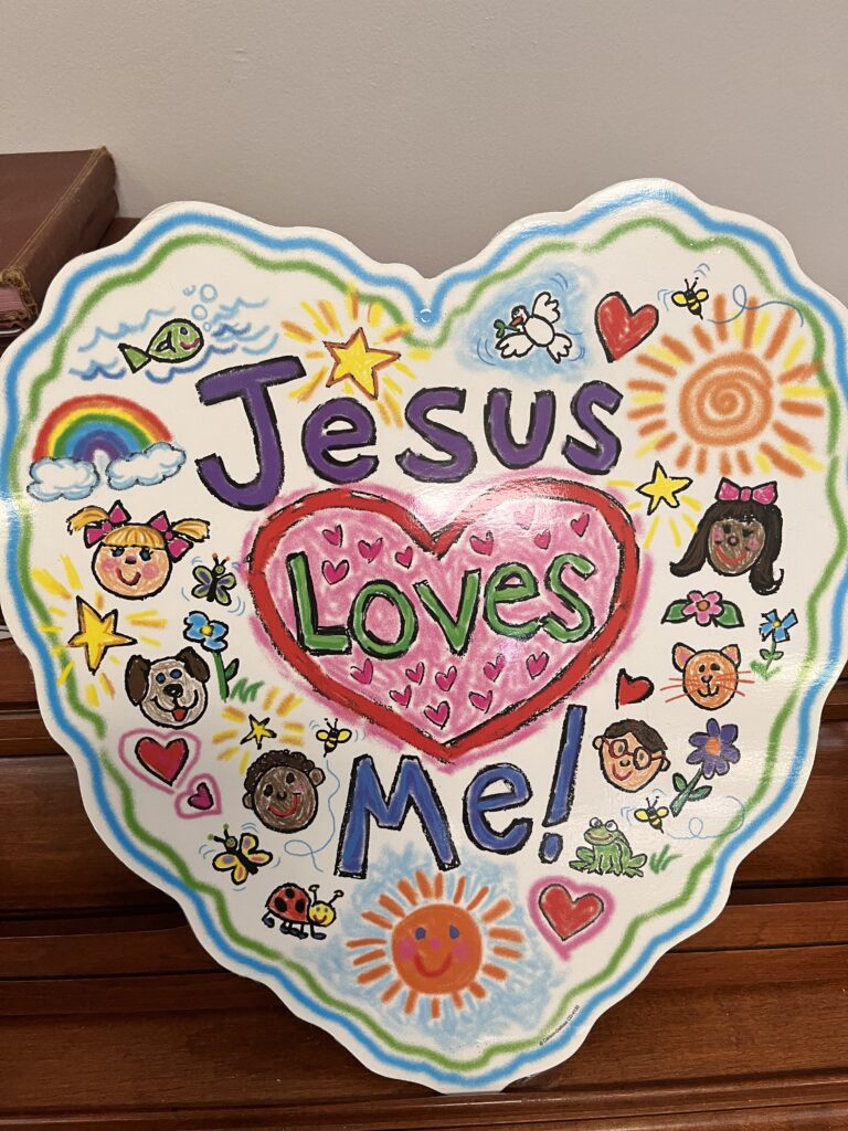 A heart shaped plate with jesus loves me written on it.