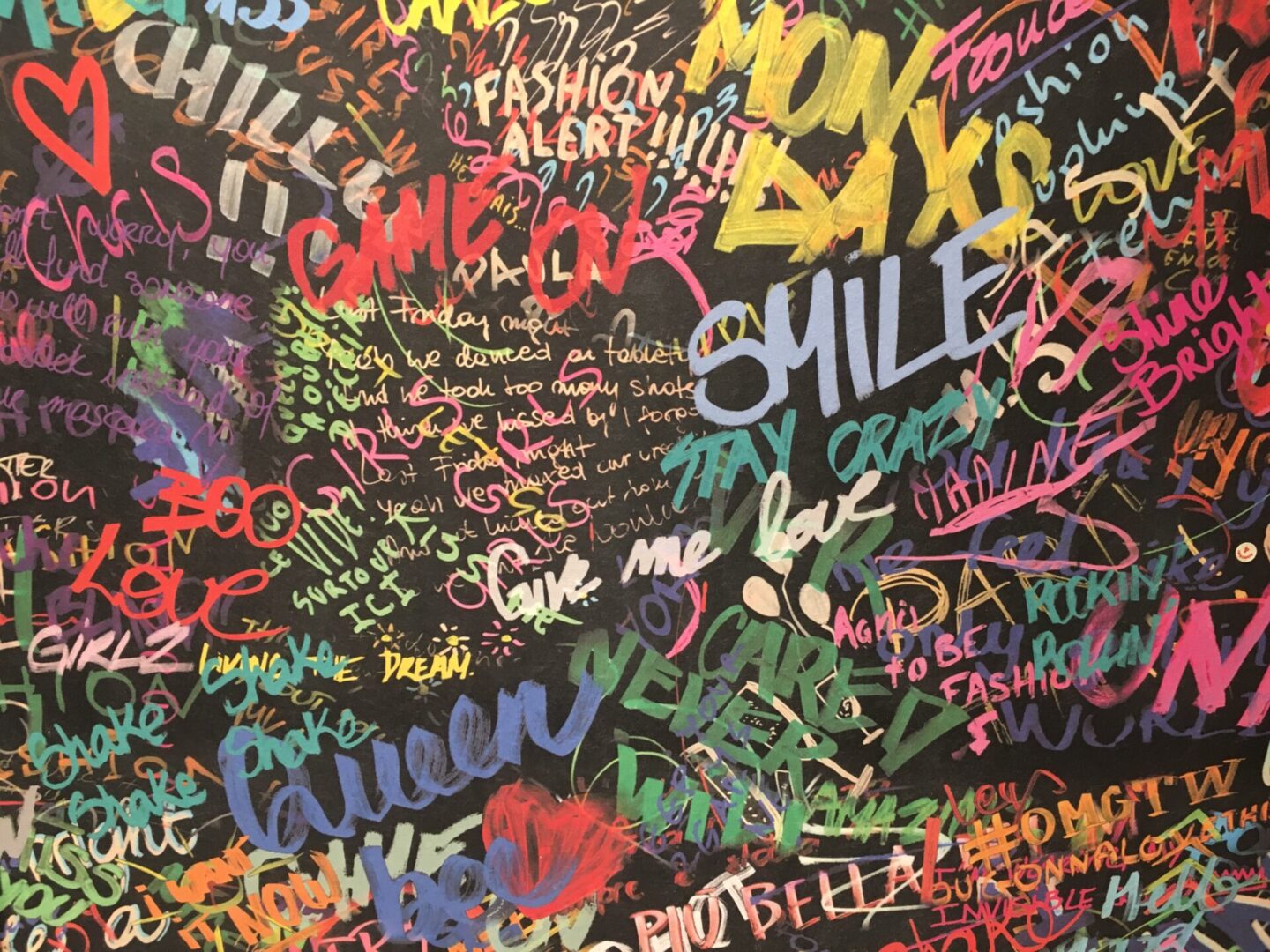 A wall covered in graffiti and writing.