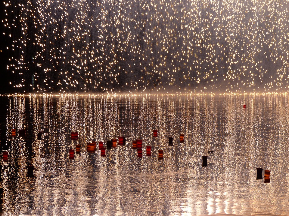 A flock of birds flying over water.