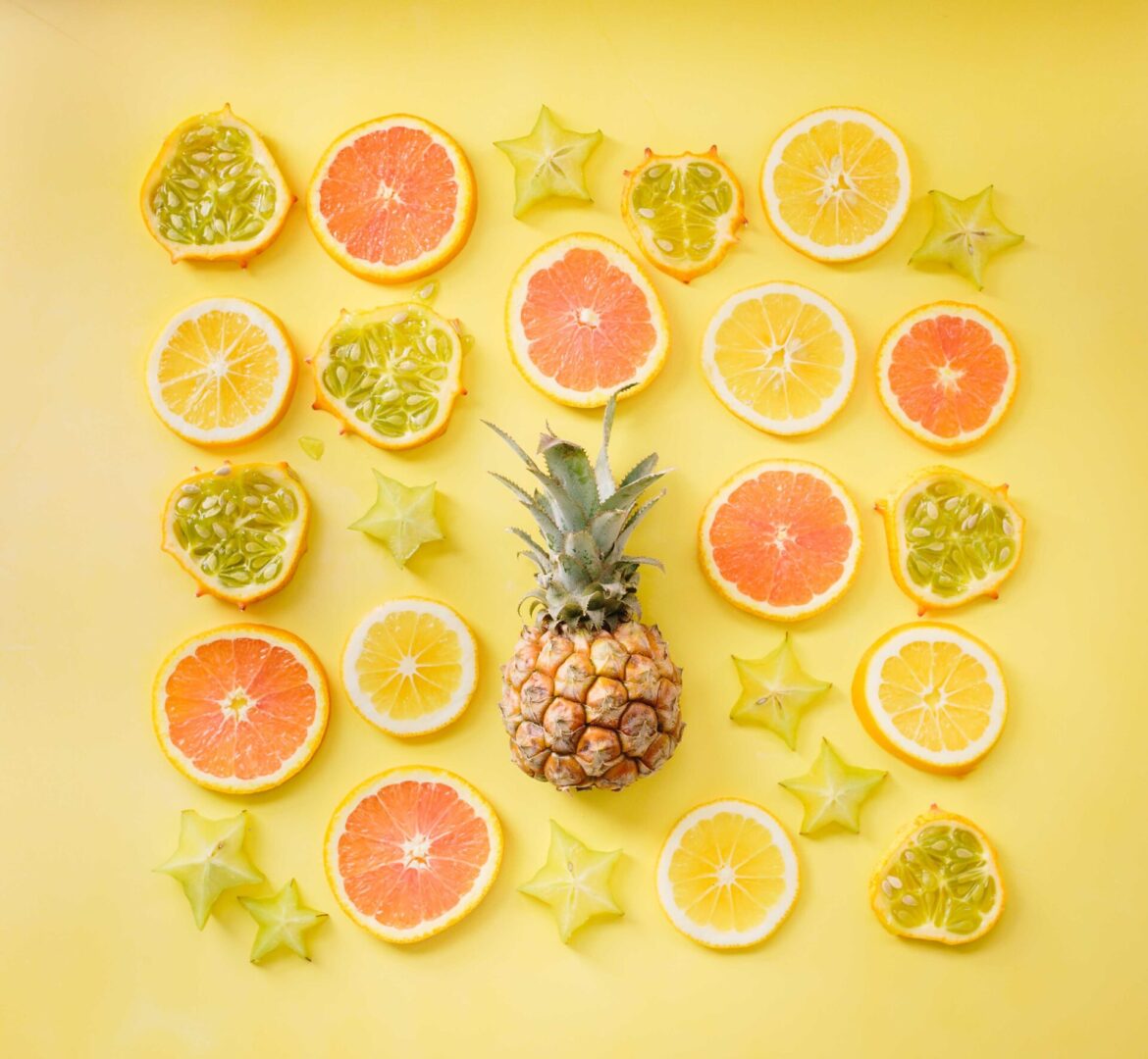 A pineapple and some cut up citrus fruits