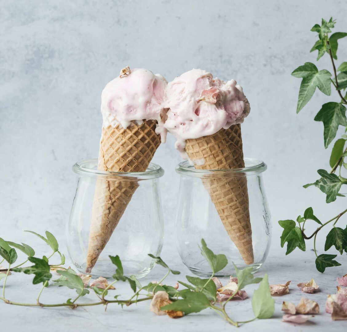 Two ice cream cones sitting on top of a table.